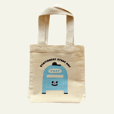 Beige tote bag with a blue post box design and text on a white background