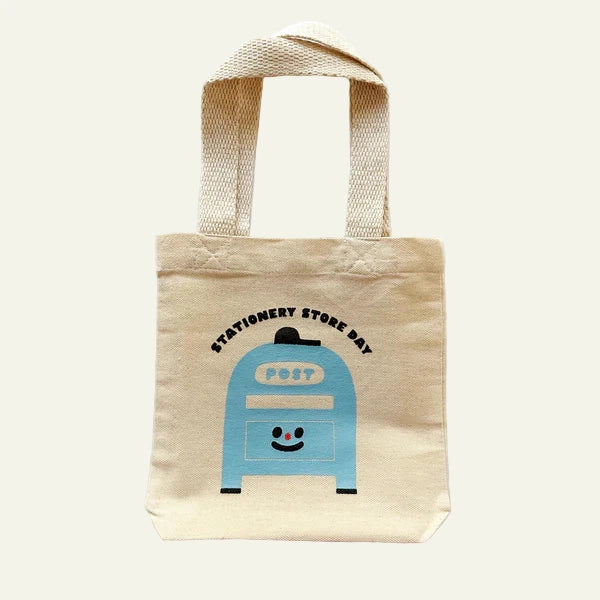 Beige tote bag with a blue post box design and text on a white background