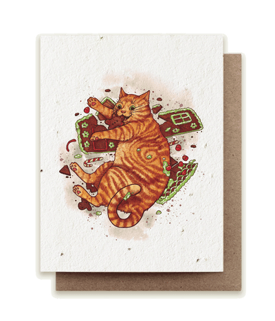 A photo of a plantable seed card with our original illustration of an orange tabby cat (Felis catus) triumphantly munching on a broken gingerbread house