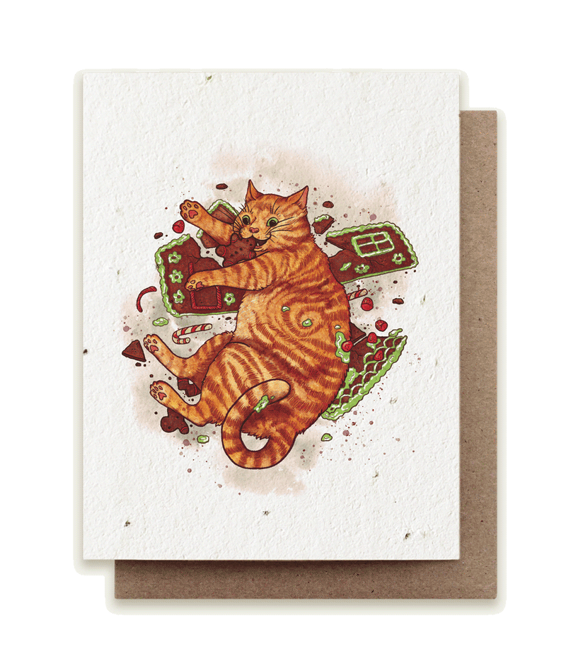 A photo of a plantable seed card with our original illustration of an orange tabby cat (Felis catus) triumphantly munching on a broken gingerbread house